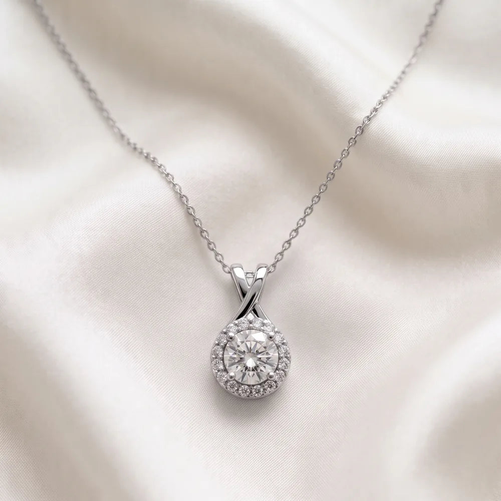Halo pendant design in white gold presented on ivory silk