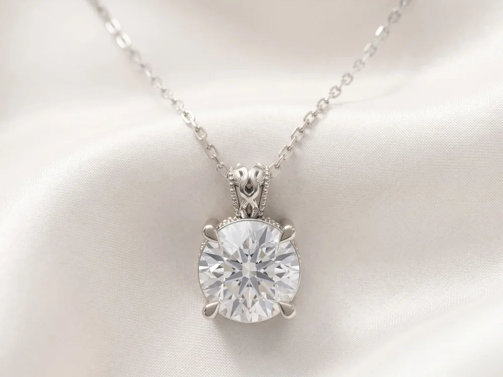White gold solitaire pendant with a round diamond on ivory silk